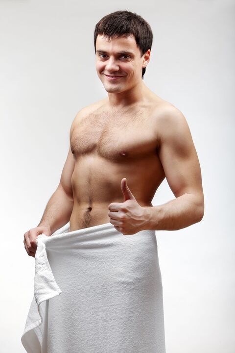 the man in a towel is pleased with the increased size of his penis